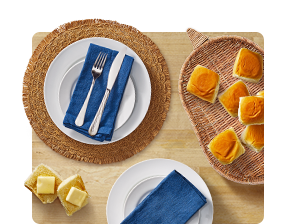 Woven serving platter, plates, napkins and silverware.
