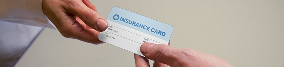 Patient giving their insurance card to a clinician.