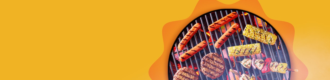 Hot dogs, hamburger patties, corn and kebabs with grill marks on a charcoal grill.