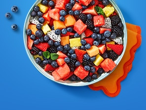 Bowl of fresh-cut watermelon, pineapple, dragonfruit, strawberries and blueberries.