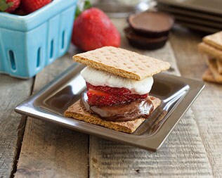 Jelly filled smore on silver plate on a wooden table Jelly filled smore on silver plate on a wooden table