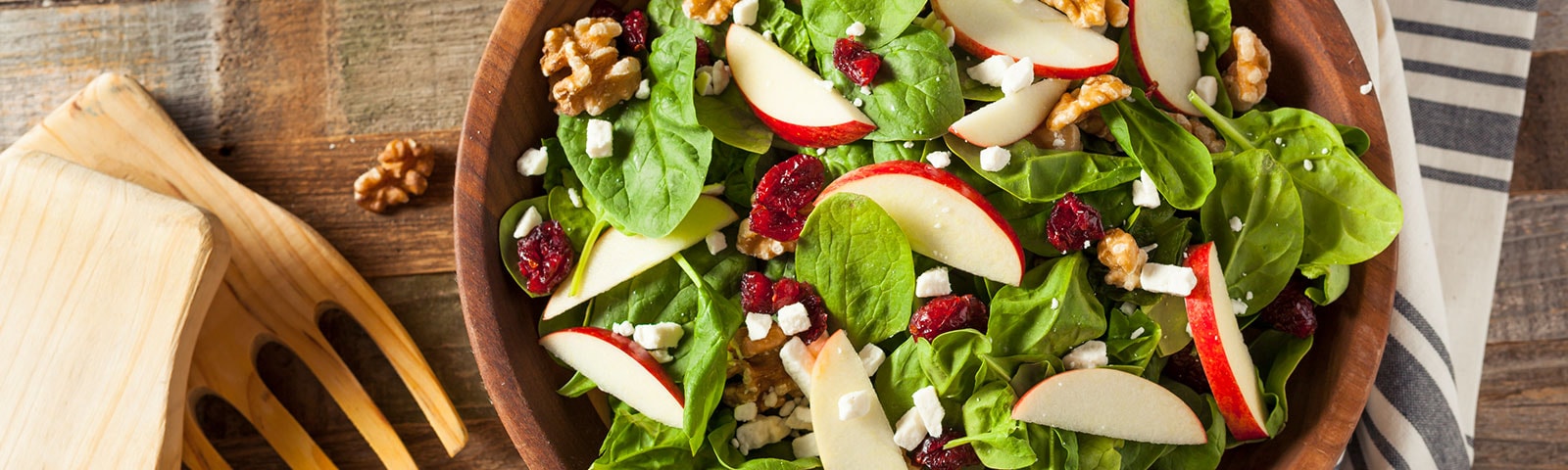 Apple, walnut and spinach salad in a serving bowl