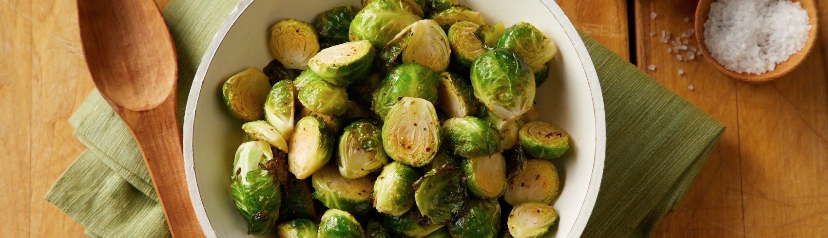 A bowl of Brussels sprouts on a wooden table