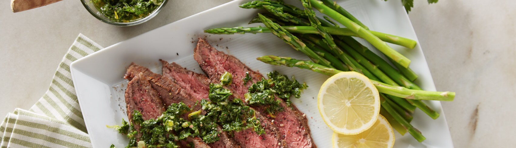 A plate with steak, asparagus and lemon slices