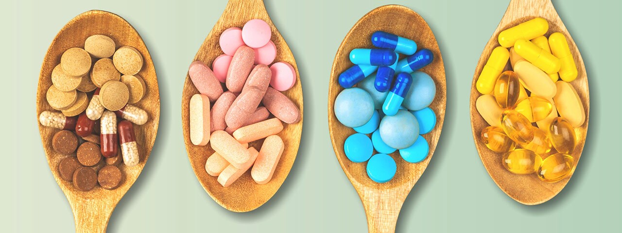 Vitamins and supplements on wooden spoons