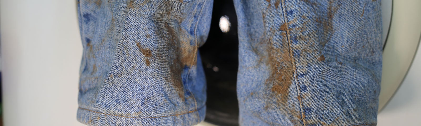 A pair of jeans covered with brown stains A pair of jeans covered with brown stains