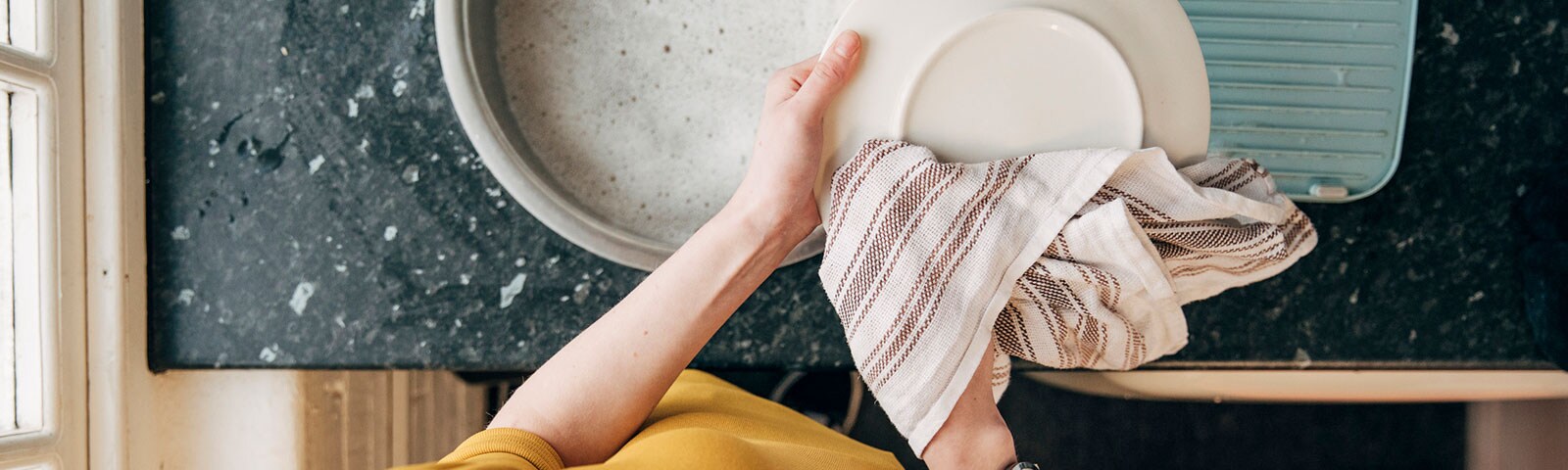 A pair of hands drying dishes A pair of hands drying dishes