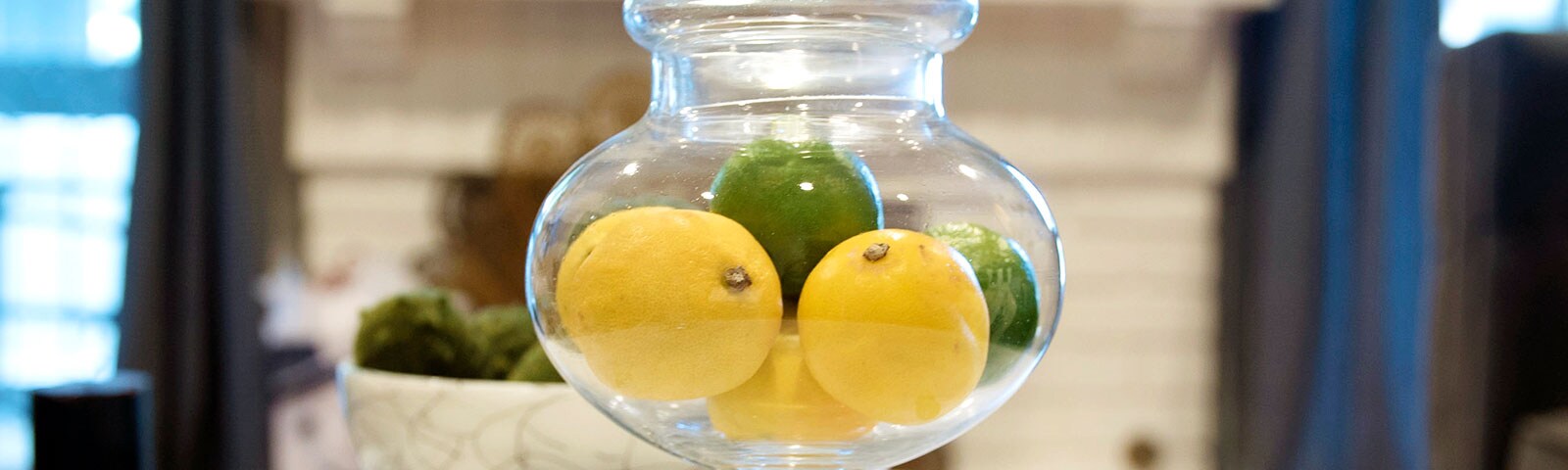 Lemon and Limes in a glass jar on a table