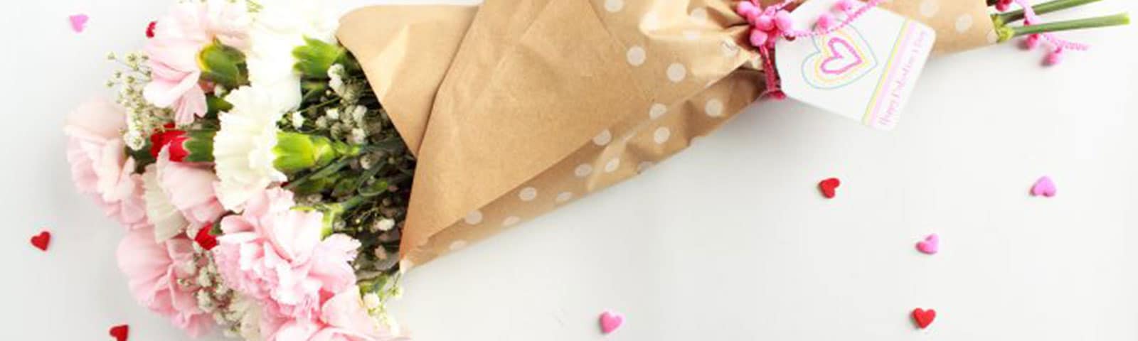 Pink, white, and red carnations flowers wrapped in brown tissue paper as a boutquet