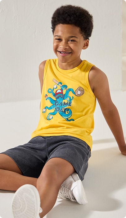 Young boy wearing a yellow tank top with a blue squid on it that says Game Day!